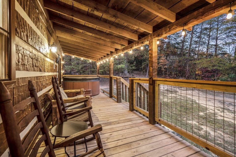 Back deck with hot tub, log-furniture futon, rocking chairs, and hook-and-ring.