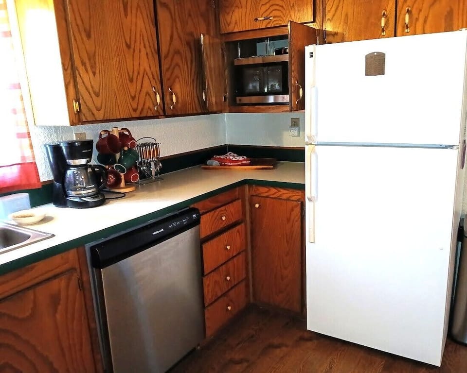 Kitchen showing full-size fridge and microwave (in the upper cabinet)