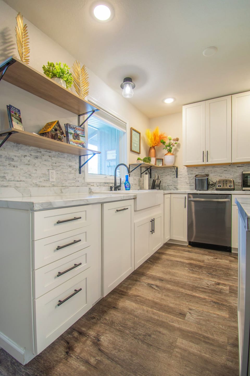 Kitchen with dishwasher, toaster, microwave and farmhouse sink.