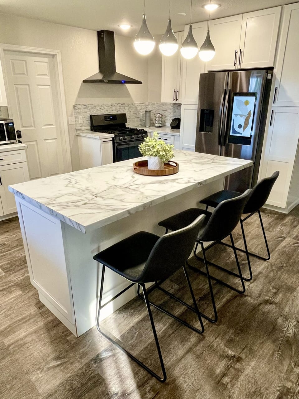Kitchen with island that seats three and a Keurig. 