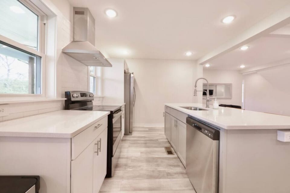 Stocked kitchen with island. Drip coffee pot, small crock pot, mixer, pots and pans