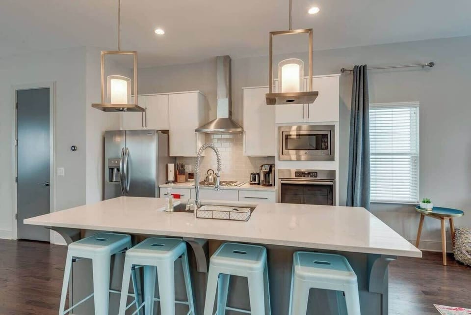 Modern kitchen with stainless appliances, bar seating, and space to cook.