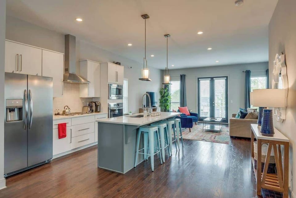 Spacious open-concept living and dining area centered around an oversized kitchen island, perfect for gathering and entertaining.