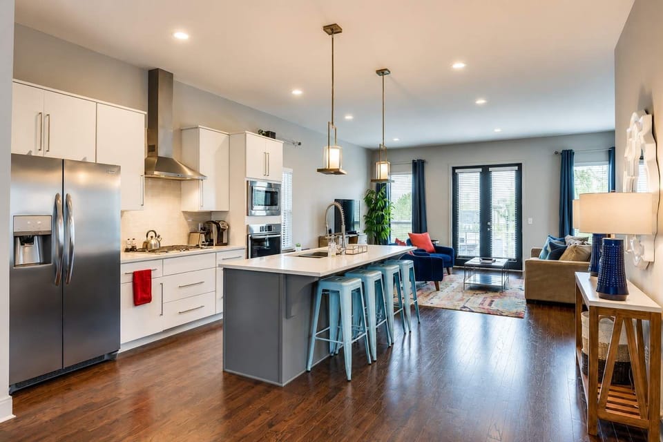 Spacious open-concept living and dining area centered around an oversized kitchen island, perfect for gathering and entertaining.