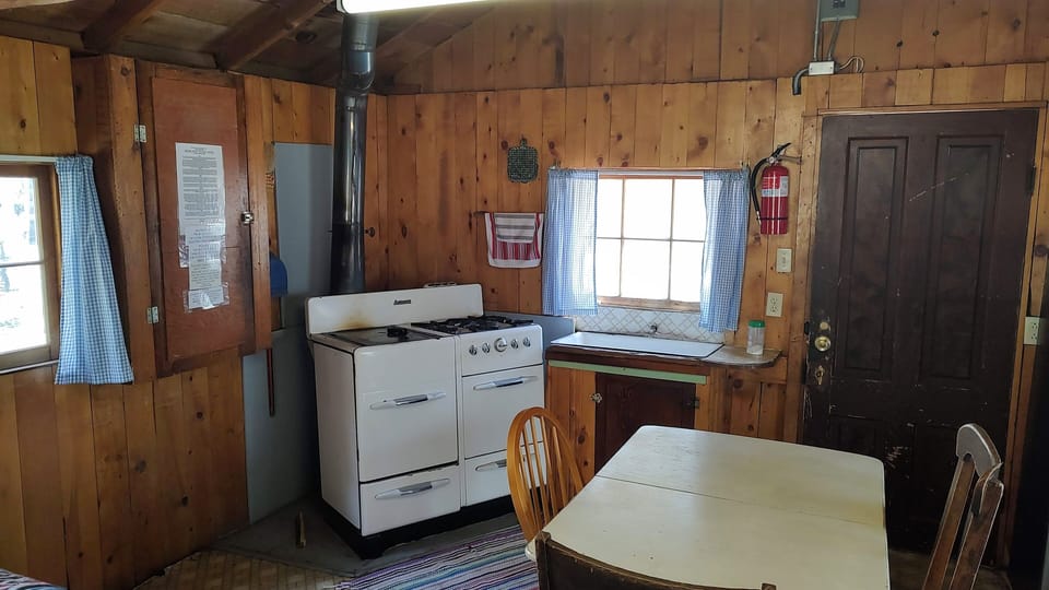Cabin 7 is a cozy rustic cabin that features a half propane/ half wood-burning stove. (2)