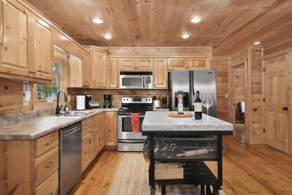 A sleek kitchen with stainless steel appliances, a spacious island and everything you need, fully stocked and ready for culinary adventures.