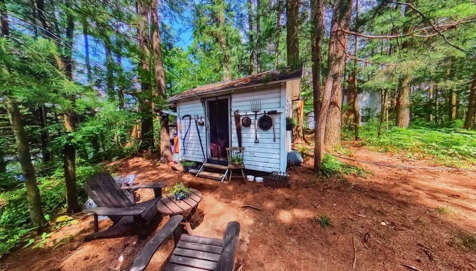 The Stabbin Cabin - Adirondack Chair and Table with BBQ Grill and Hammock just out front.  Mini Fridge on left side of Cottage