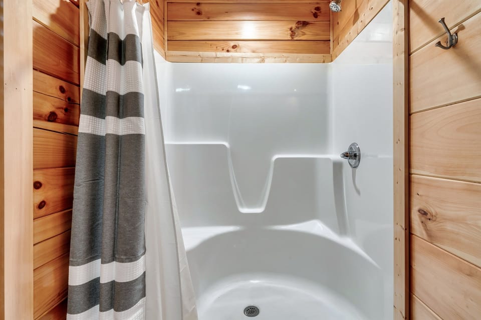 Another main level ensuite bathroom boasts a roomy walk-in shower, providing the perfect blend of comfort and convenience for a relaxing stay.
