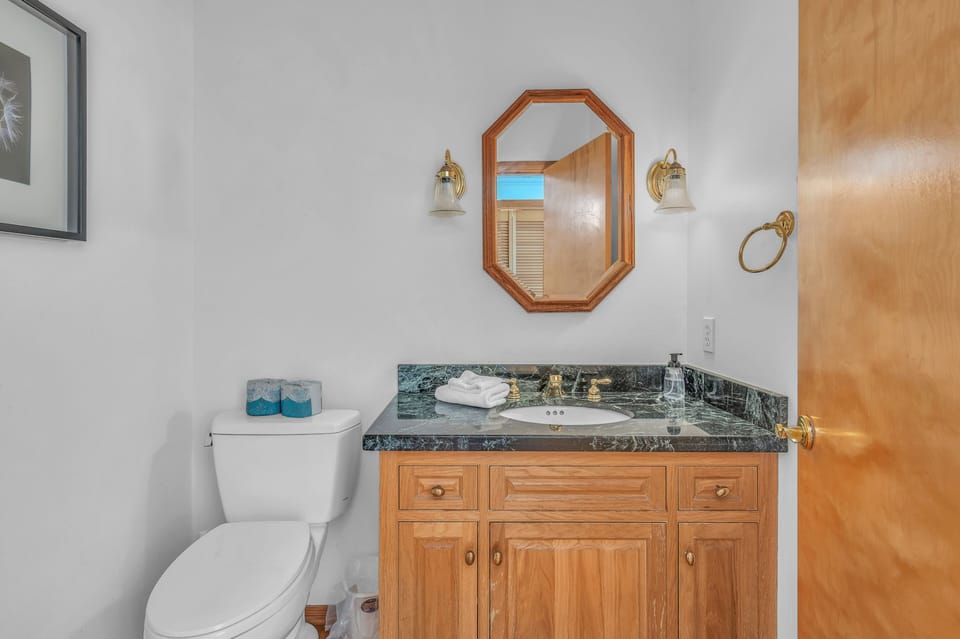 Step into your elegantly appointed bathroom featuring warm wood cabinetry and sophisticated granite countertops for a luxurious daily routine.