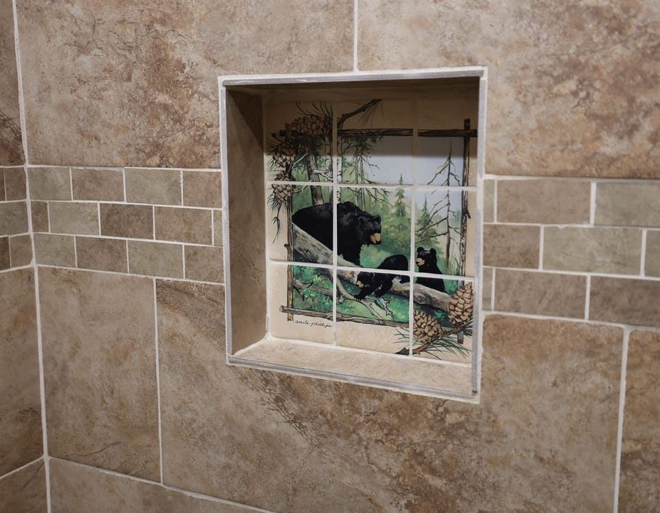 Shower with custom black bear tile accents
