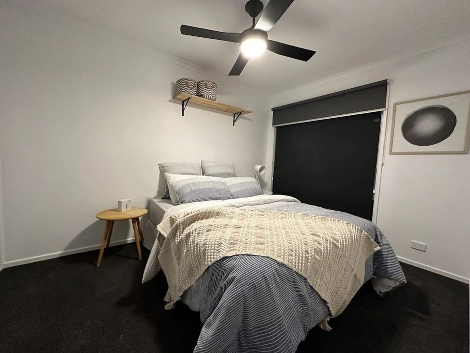 edroom 5 downstairs with queen bed and ceiling fan.