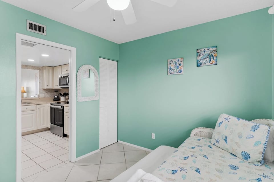 Your tranquil bedroom features soothing seafoam walls and coastal-themed bedding, creating the perfect seaside retreat for restful nights.