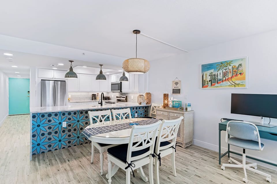 Embrace coastal vibes in your bright open kitchen with vibrant blue tile and dining space perfect for morning coffee or evening meals.