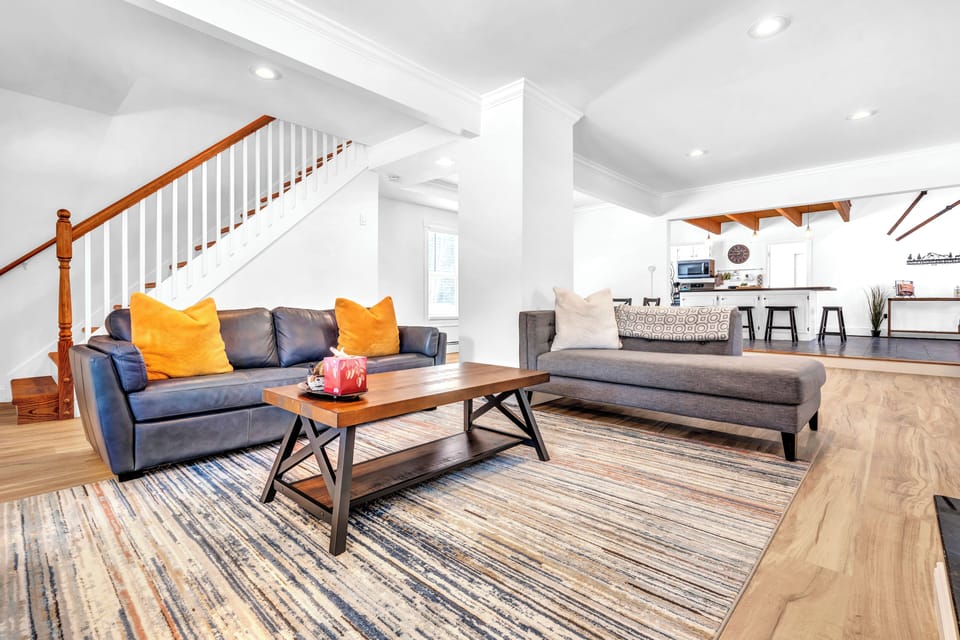 Bright open-concept lounge with stylish seating and island kitchen nearby