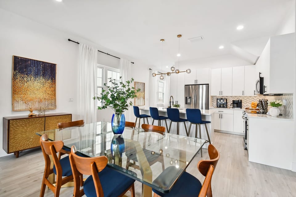Designer dining table for 6 in a modern open space area: sleek, minimalist style, perfect for gatherings, complements the room's contemporary aesthetic with its elegant and functional design.