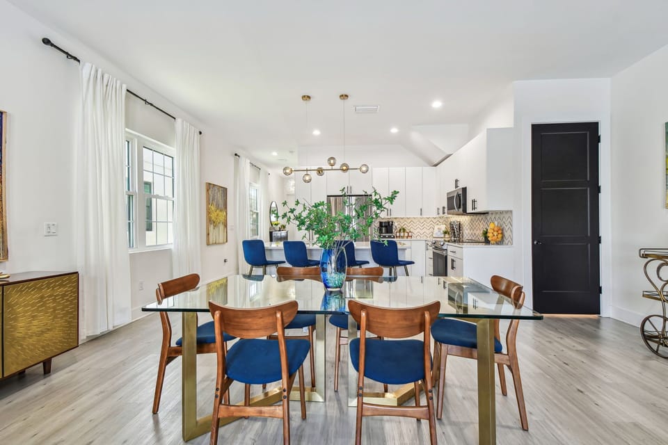 Designer dining table for 6 in a modern open space area: sleek, minimalist style, perfect for gatherings, complements the room's contemporary aesthetic with its elegant and functional design.