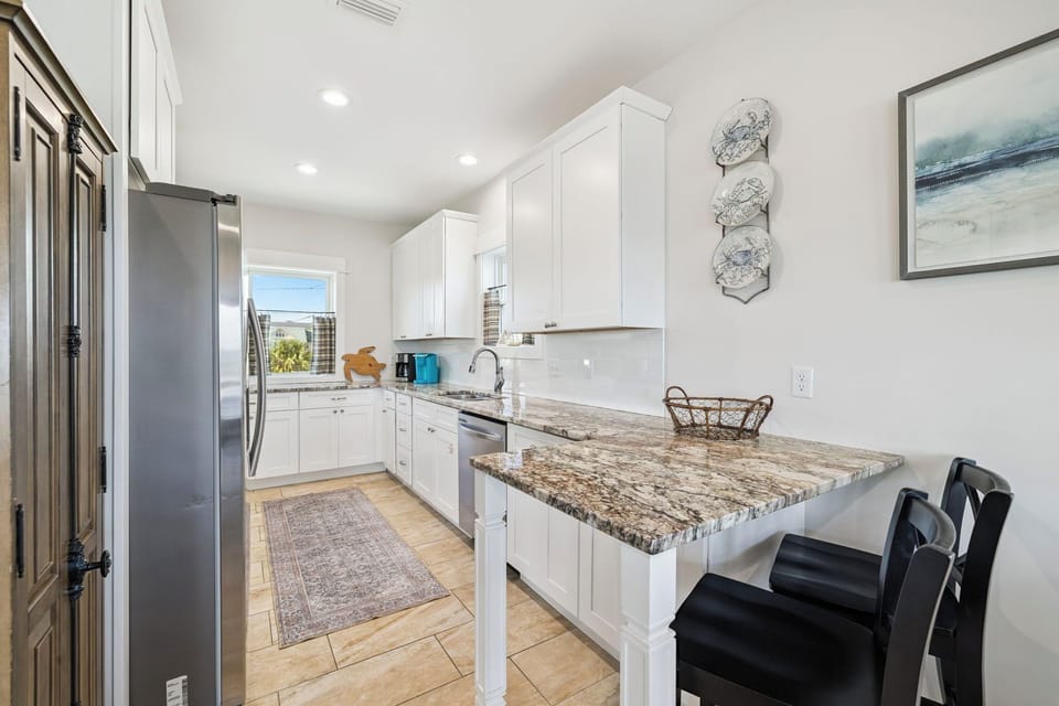 Gather around this spacious kitchen with gleaming granite countertops and modern stainless appliances—perfect for whipping up your favorite meals or sipping morning coffee at the island breakfast bar.