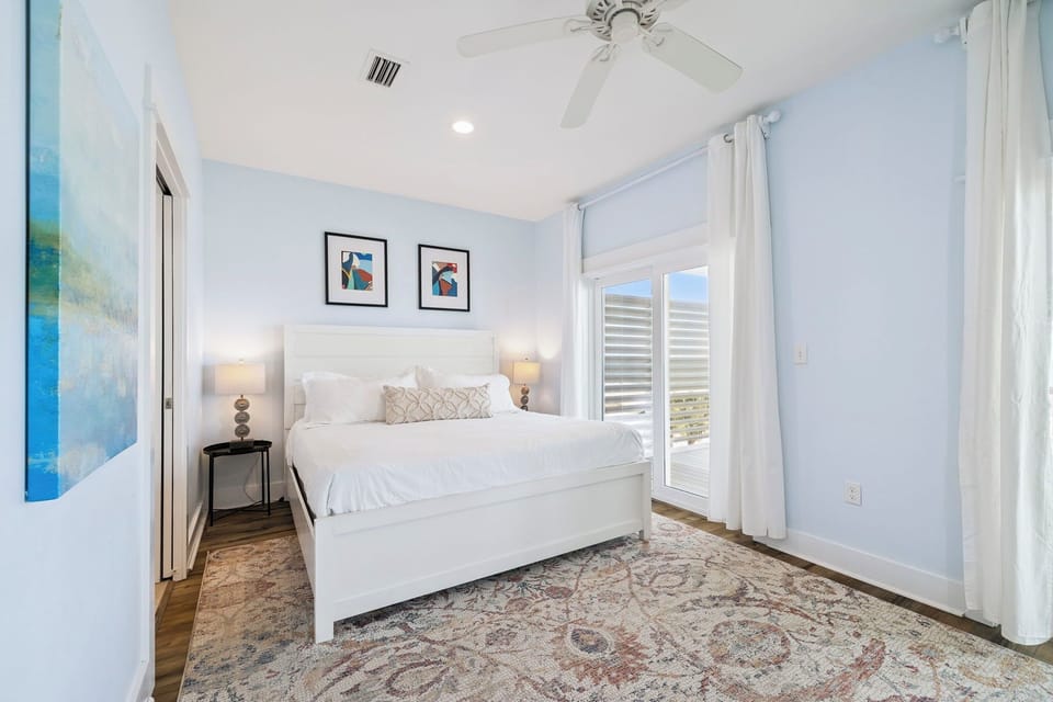 Drift off in this serene bedroom, where soft linens and gentle breezes from the ceiling fan promise restful nights. Your private retreat awaits beyond the shuttered doors.