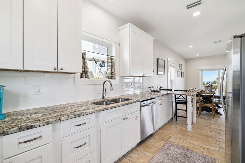 Your well-equipped kitchen features granite countertops, stainless steel appliances, and bright white cabinetry—perfect for preparing home-cooked meals during your stay.
