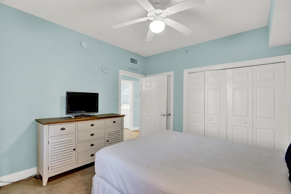 Drift off in this tranquil bedroom with soft blue walls, crisp linens, and coastal charm. Your private retreat awaits.