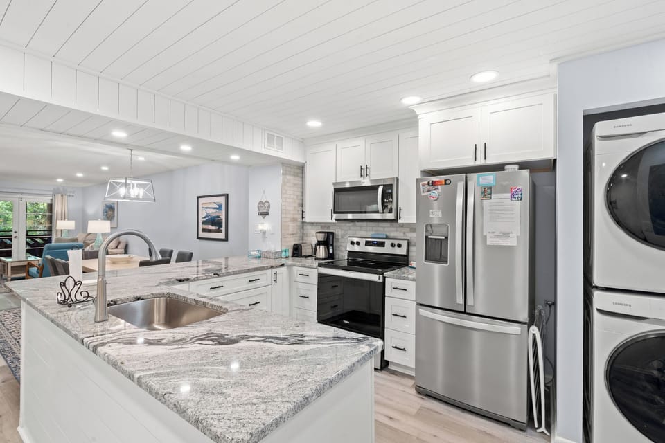 Step into your beautifully designed kitchen featuring gleaming granite countertops, stainless steel appliances, and bright white cabinetry—perfect for preparing meals or gathering with loved ones in this welcoming, open-concept space.
