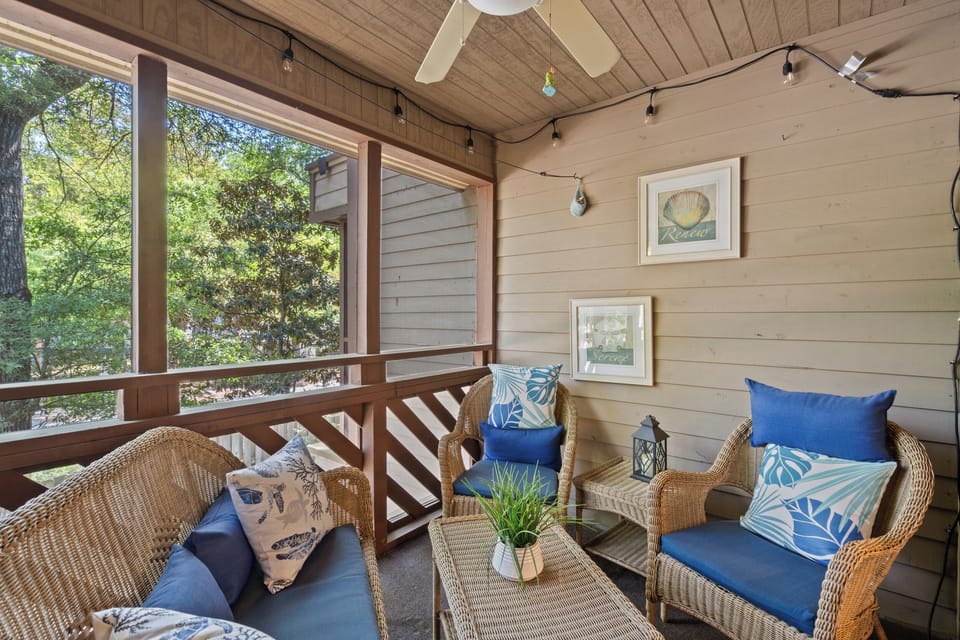 Unwind in your private screened porch, where breezy afternoons and morning coffee feel effortlessly peaceful. Soft cushions, coastal touches, and glimpses of greenery create your perfect retreat.