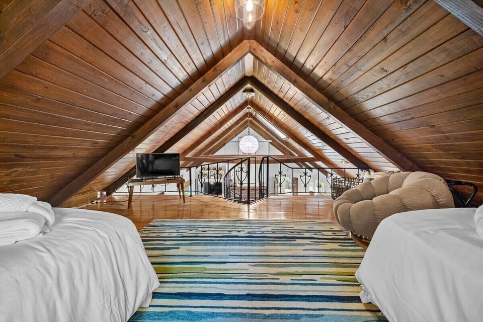 Head up the spiral staircase to enter our fourth bedroom, which is complete with two Twin-size beds, Vizio Smart TV, lounge chair and nearby bath.