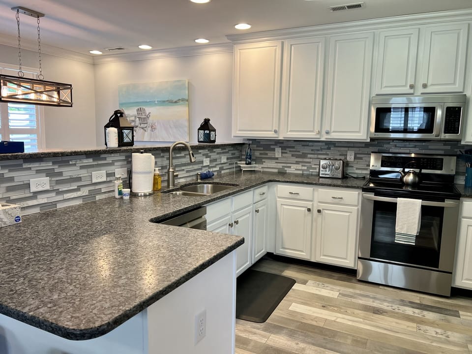 Spacious kitchen with upgraded countertops, backsplash, and appliances. 