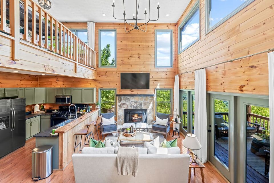 Main level living room with gas fireplace + kitchen + dining area. 