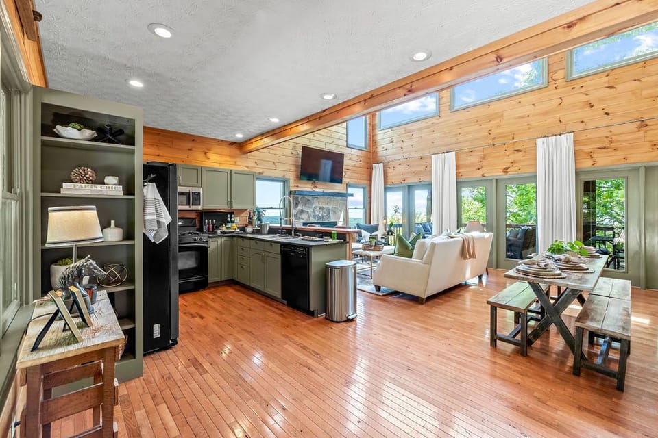 Main level living room with gas fireplace + kitchen + dining area. 