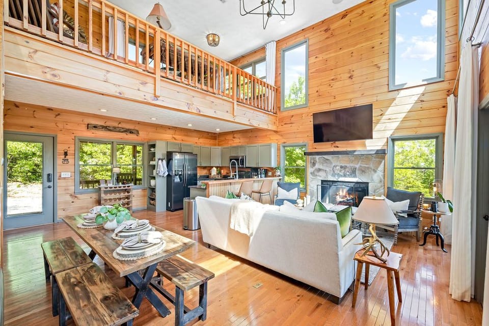 Main level living room with gas fireplace + kitchen + dining area. 