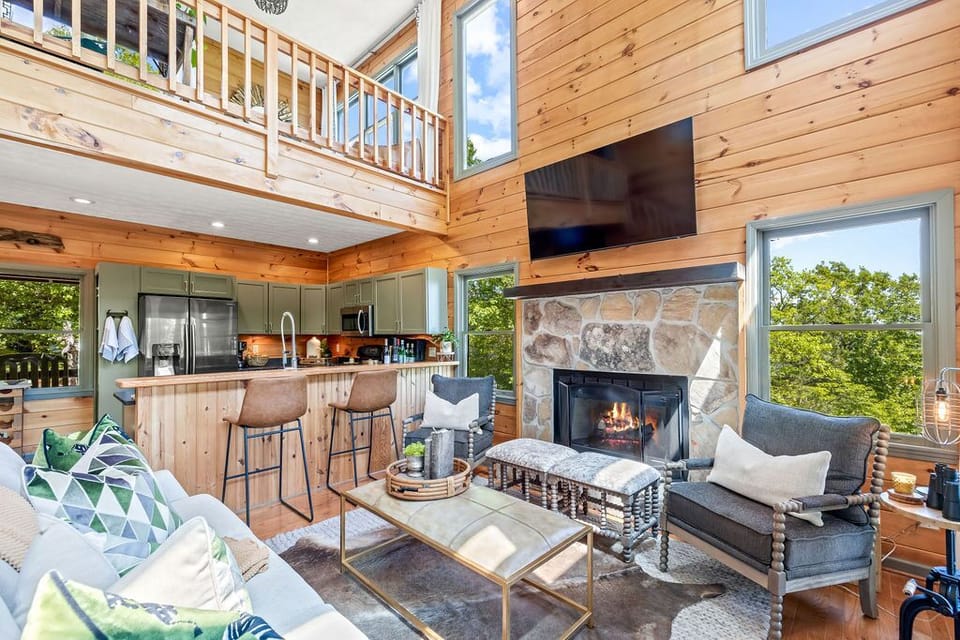 Main level living room with gas fireplace + kitchen + dining area. 