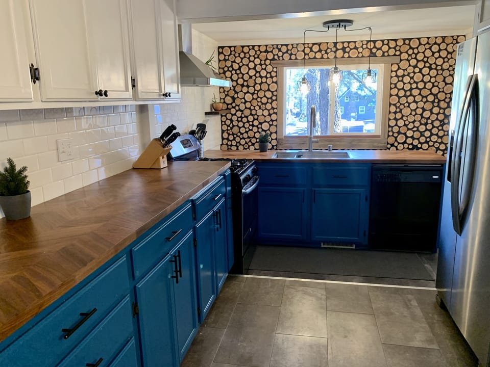 A recently renovated kitchen with log round accent wall.  Wood from the property