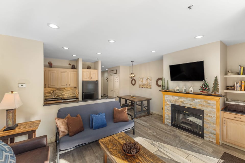 Living area featuring updated furnishings, gas fire place, mounted smart TV, and beautiful views of the lake and mountains.