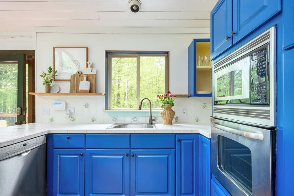 Kitchen features modern appliances and beautiful blue.