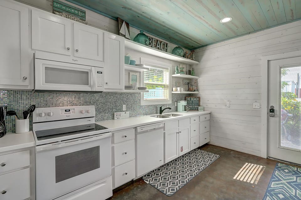 Your fully equipped beach-style kitchen features white cabinets, coastal decor, and everything you need to create memorable meals during your stay.