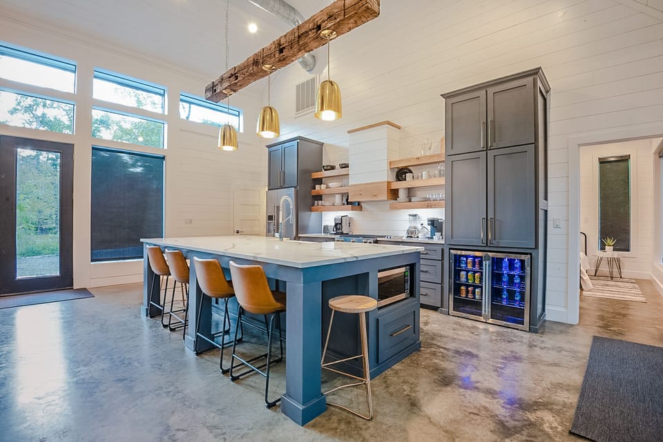 The Barndo’s kitchen is one of Broken Bow’s most iconic with modern elements including a large calacatta quartz countertop with bar seating, stainless steel appliances, and beverage coolers.