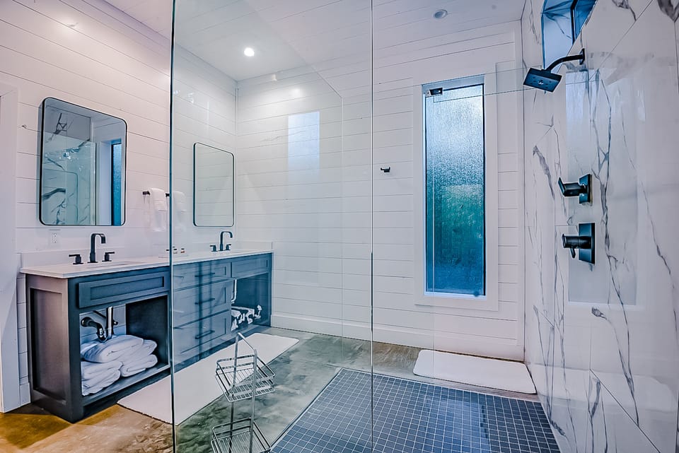 The cabin's master bathrooms provide a luxury spa experience with rainfall shower head, extra shower head, custom temperature controls, and privacy windows for light without compromising privacy.