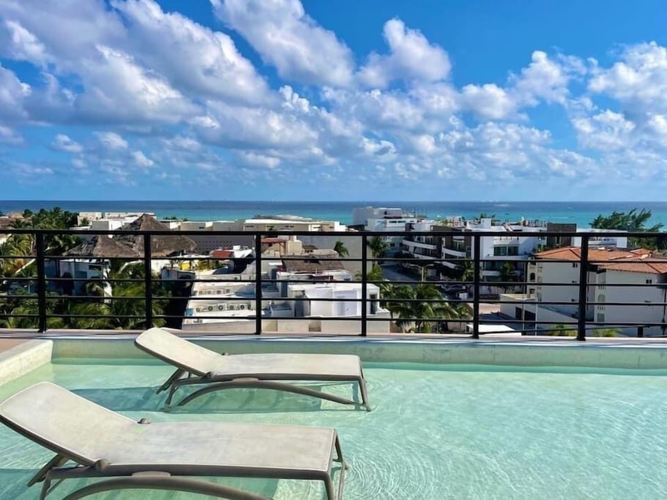 Shared rooftop terrace with pool and city/ocean views
