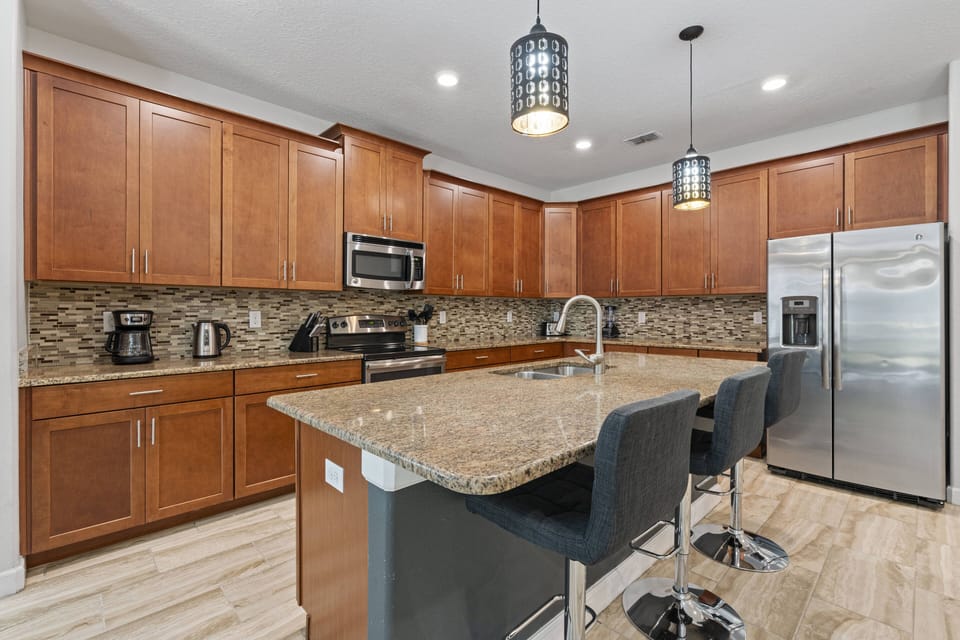 Experience a stylish kitchen with rich wooden cabinetry and sleek granite countertops that inspire culinary creativity. Modern appliances and elegant pendant lighting enhance the ambiance, while the open layout is perfect for.