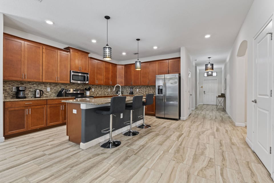 Enjoy a bright and spacious contemporary kitchen with rich wood cabinetry and sleek granite countertops, perfect for your culinary adventures.
