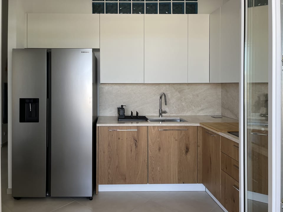 Brand-new kitchen with American-style fridge and induction stove.