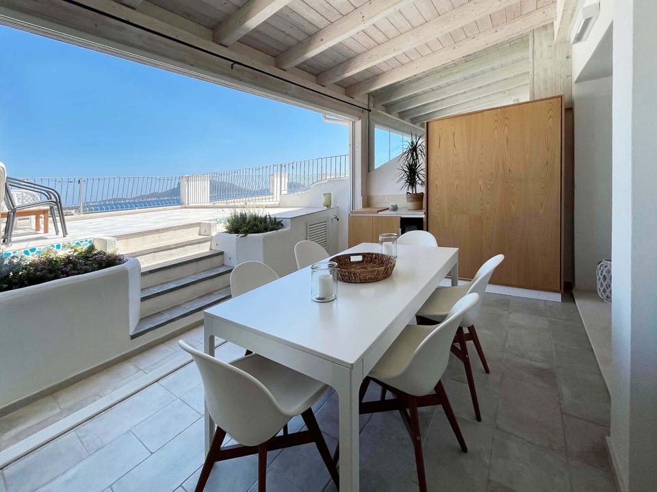 Porch with extendable dining table (6-8 guests) with a sea view. 