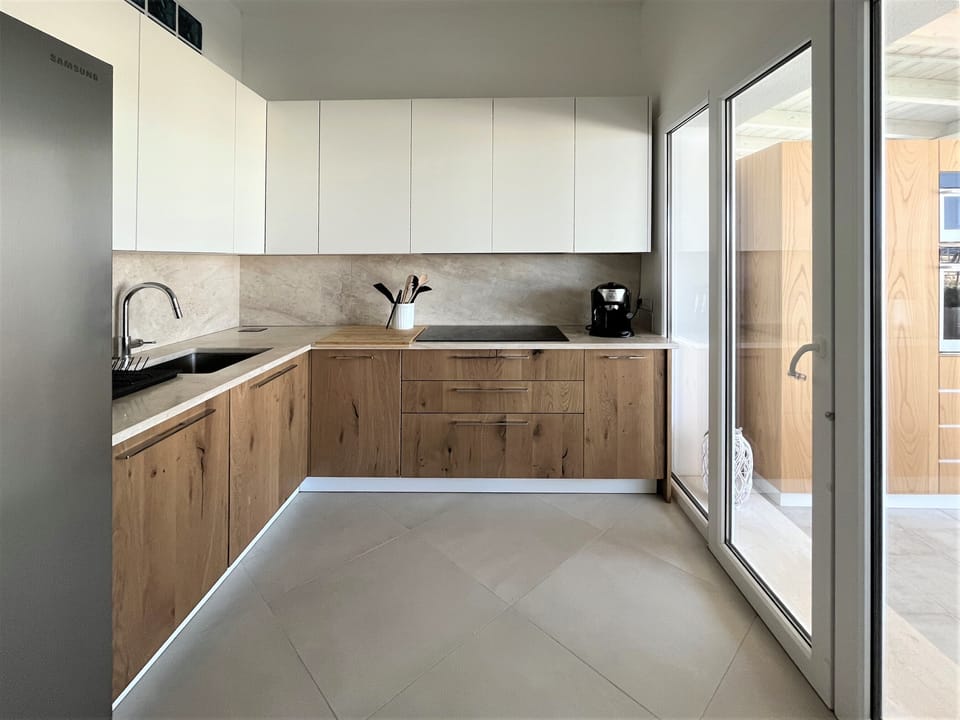 Brand-new kitchen with American-style fridge and induction stove.