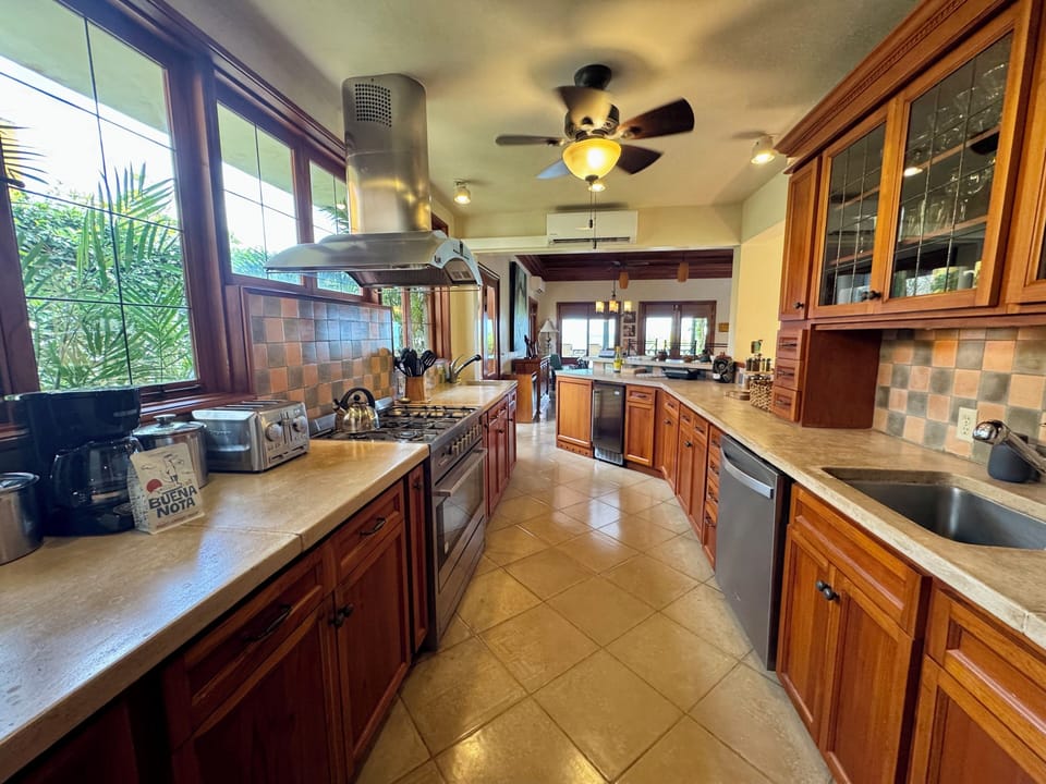 The custom kitchen is right next to the dining table and living area for family cooking but far enough for a private chef