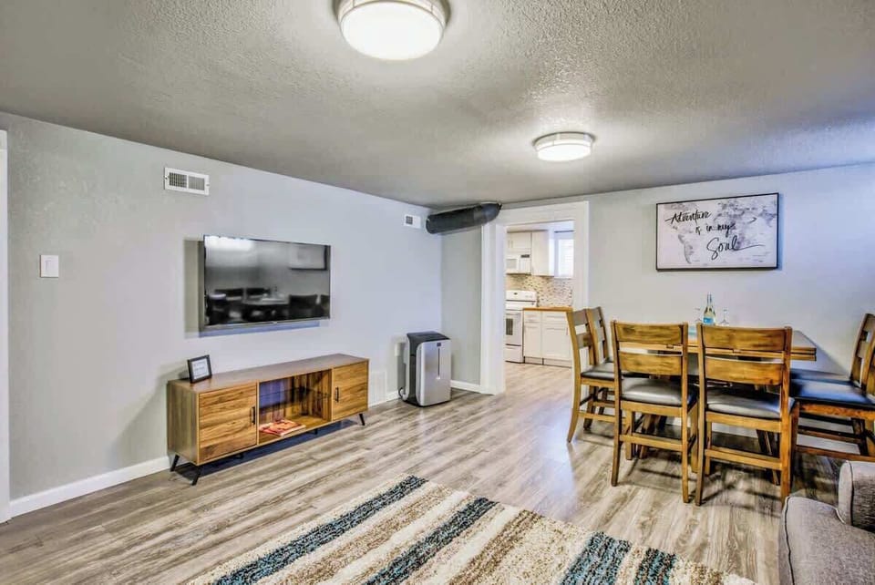 The open and spacious living room features the dining table, a queen-sized sleeper sofa, and a 55 inch 4k Roku Smart TV!