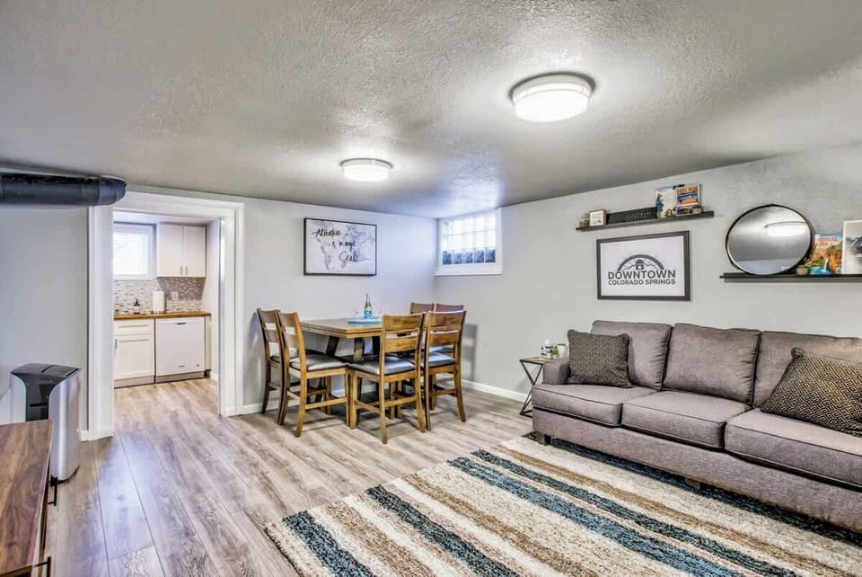 The open and spacious living room features the dining table, a queen-sized sleeper sofa, and a 55 inch 4k Roku Smart TV!