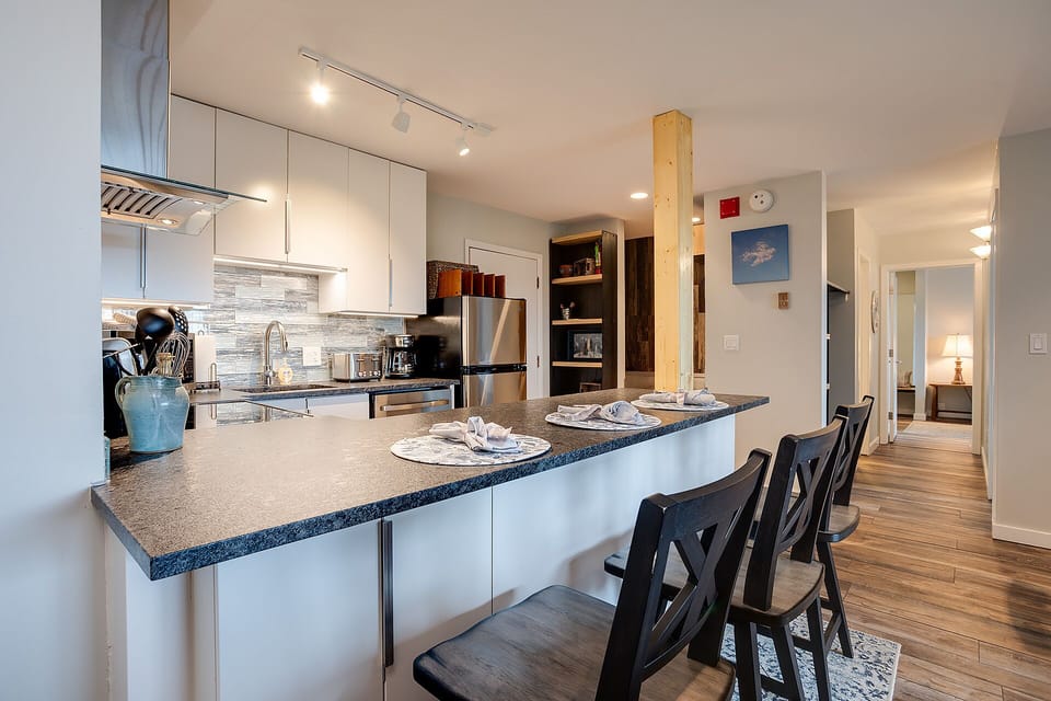 Cook and connect at your sleek kitchen island with granite counters, modern appliances, and bar seating perfect for sharing meals.