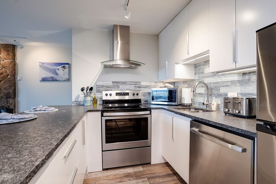 Your fully equipped kitchen features granite counters, stainless appliances, and elegant tile backsplash for memorable meal preparation.