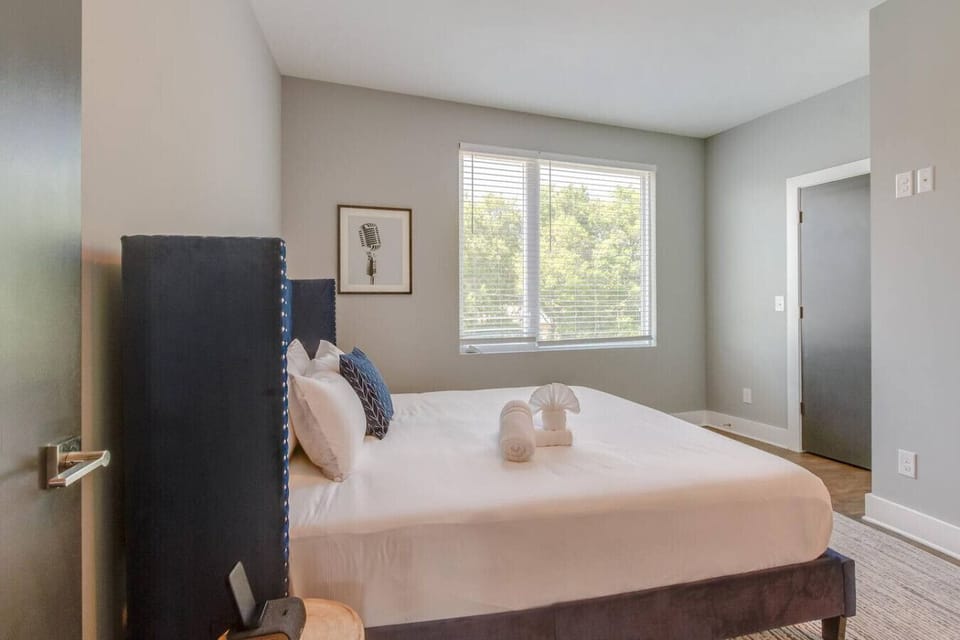 Restful bedroom with a comfortable bed, dresser, and sunlit windows